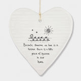 White Hanging Porcelain 'Wobbly' Round Heart from East of India which reads:  'Because someone we love is in heaven there is a little piece of heaven in our home.'  The heart features an engraved illustration in East of India's unique style.