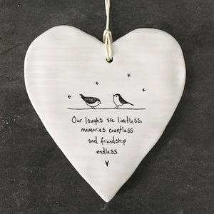 White Hanging Porcelain 'Wobbly' Round Heart from East of India which reads:  'Our laughs are limitless, memories countless and friendship endless.'  The heart features an engraved illustration in East of India's unique style.