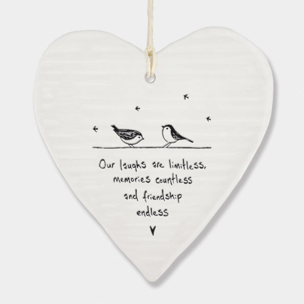 White Hanging Porcelain 'Wobbly' Round Heart from East of India which reads:  'Our laughs are limitless, memories countless and friendship endless.'  The heart features an engraved illustration in East of India's unique style.