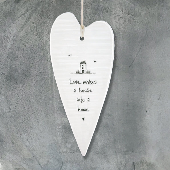 White Hanging Long 'Wobbly' Porcelain Heart from East of India which reads:  'Love makes a house into a home'  The heart also features an engraved illustration.