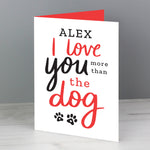 This personalised card features the wording 'I Love You More Than The Dog' and cute pawprint graphics 
