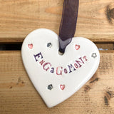Hand painted ceramic heart featuring hearts and flowers design and the sentiment 'Engagement'  Handmade in the UK using clay, glaze and paint sourced locally.