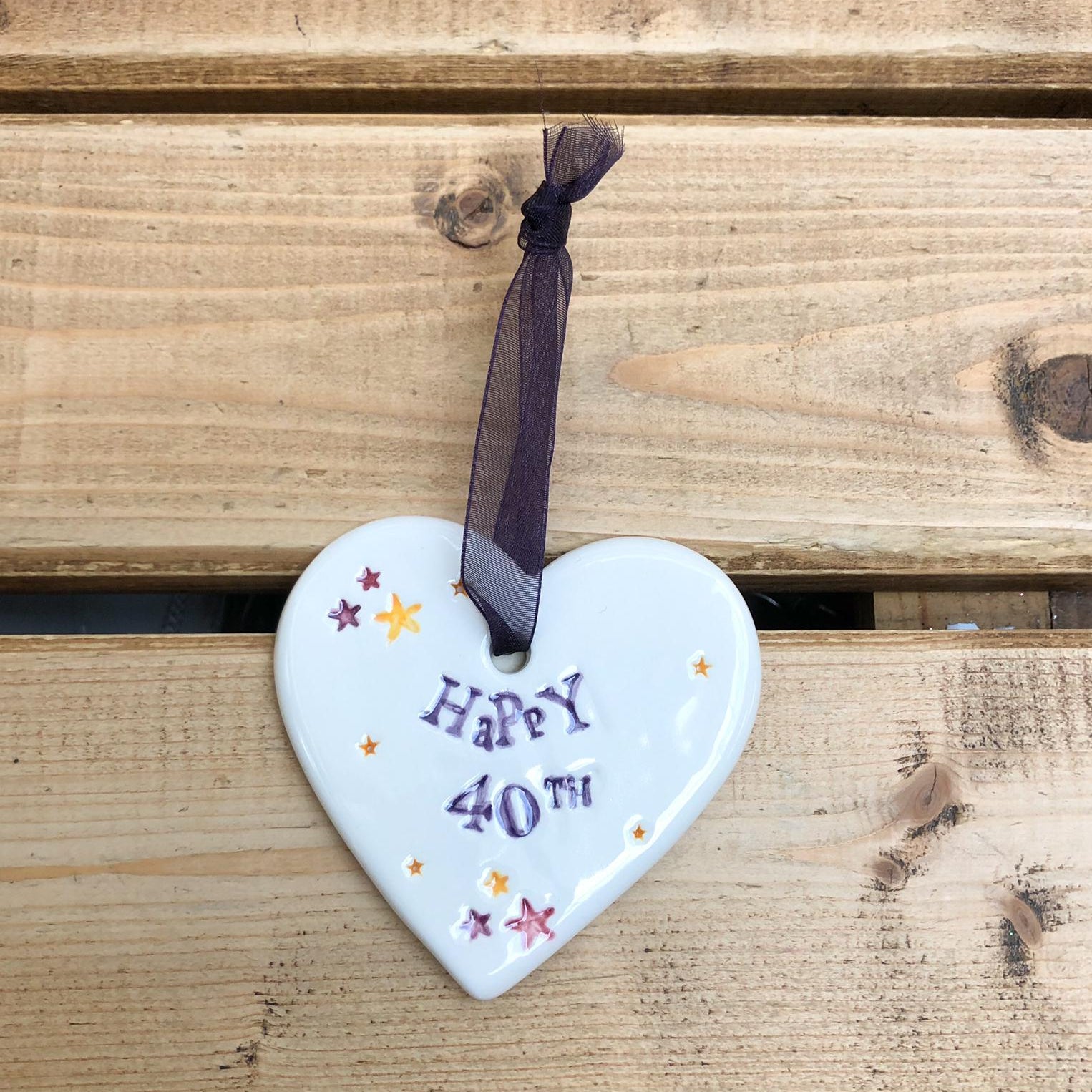 Hand painted ceramic heart featuring star design and the sentiment 'Happy 40th' Handmade in the UK using clay, glaze and paint sourced locally. Material: Ceramic