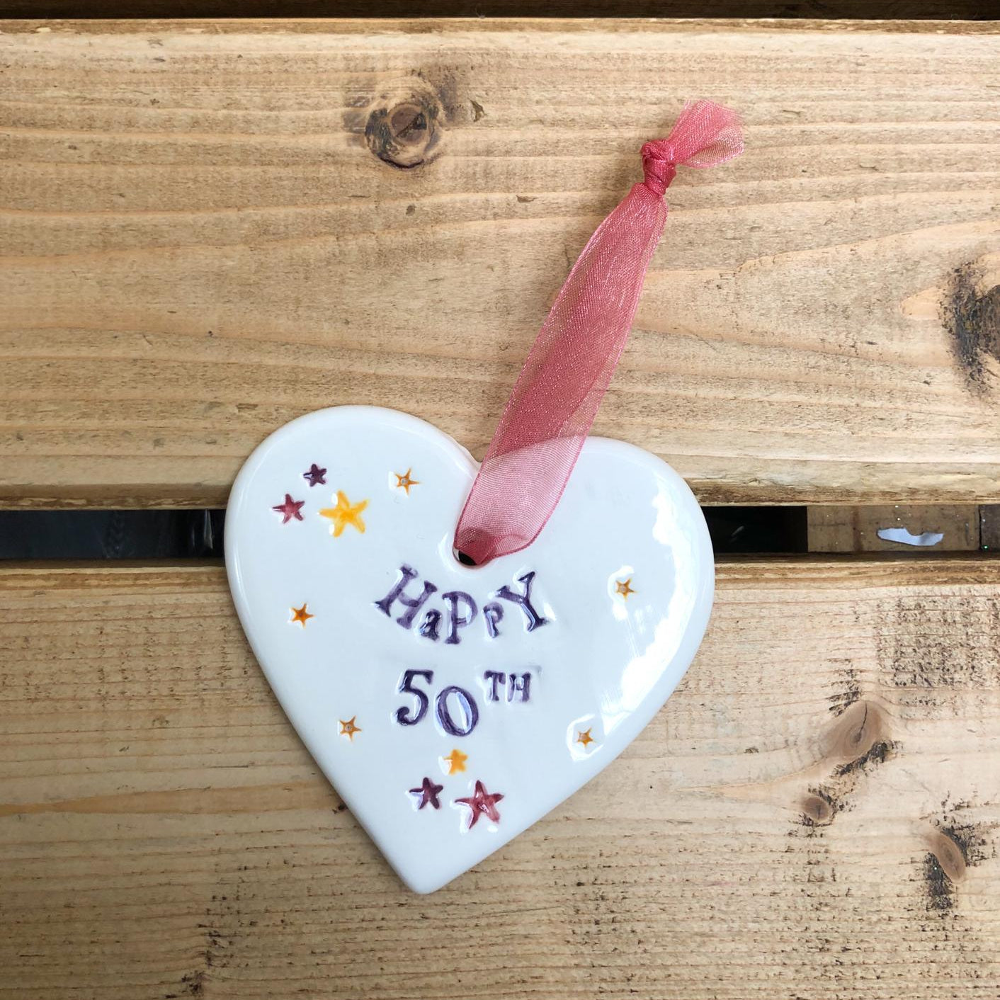 Hand painted ceramic heart featuring star design and the sentiment 'Happy 50th' Handmade in the UK using clay, glaze and paint sourced locally. Material: Ceramic