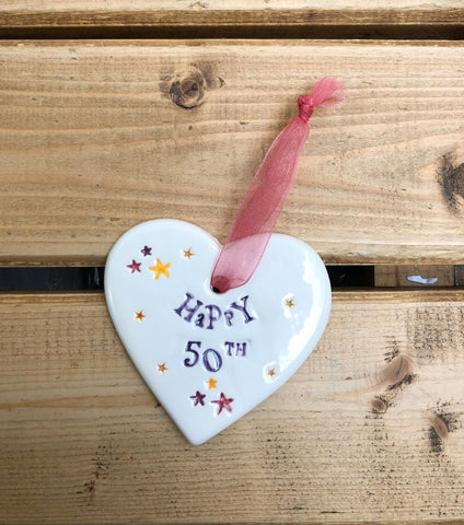 Hand painted ceramic heart featuring star design and the sentiment 'Happy 50th' Handmade in the UK using clay, glaze and paint sourced locally. Material: Ceramic