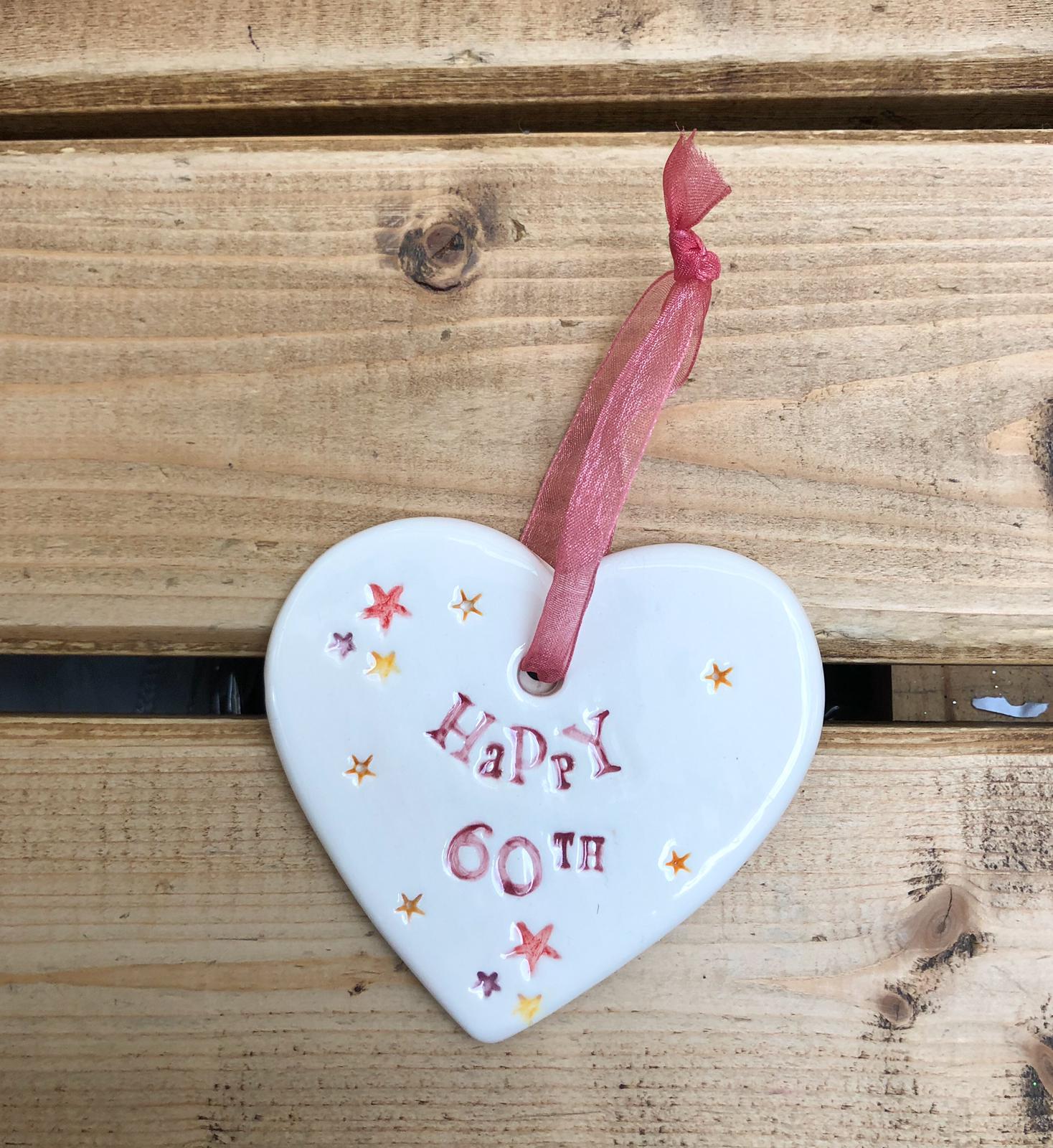 Hand painted ceramic heart featuring star design and the sentiment 'Happy 60th' Handmade in the UK using clay, glaze and paint sourced locally. Material: Ceramic