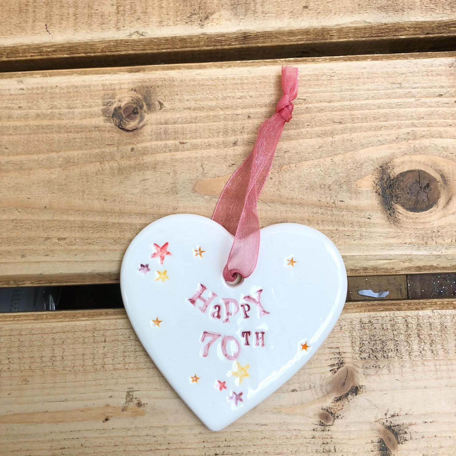 Hand painted ceramic heart featuring star design and the sentiment 'Happy 70th' Handmade in the UK using clay, glaze and paint sourced locally. Material: Ceramic