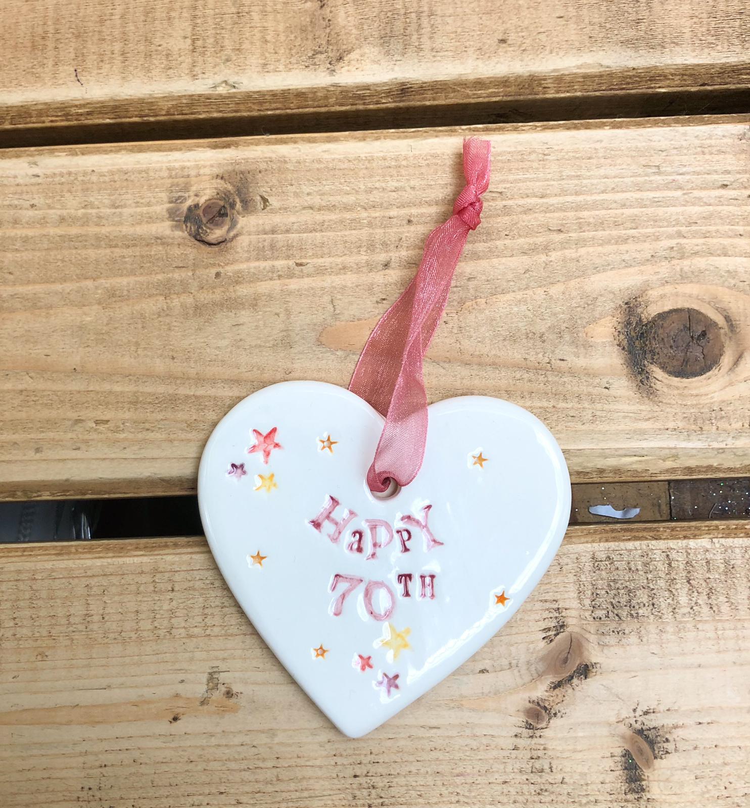 Hand painted ceramic heart featuring star design and the sentiment 'Happy 70th' Handmade in the UK using clay, glaze and paint sourced locally. Material: Ceramic