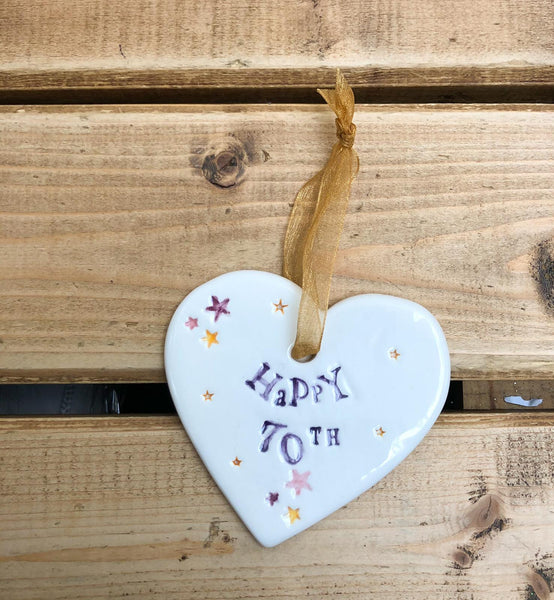 Hand painted ceramic heart featuring star design and the sentiment 'Happy 70th' Handmade in the UK using clay, glaze and paint sourced locally. Material: Ceramic