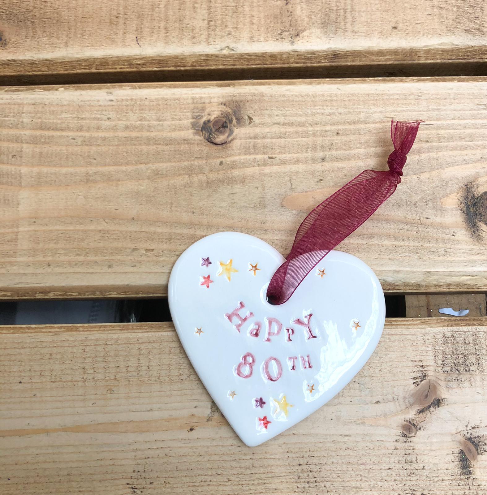 Hand painted ceramic heart featuring star design and the sentiment 'Happy 80th' Handmade in the UK using clay, glaze and paint sourced locally. Material: Ceramic
