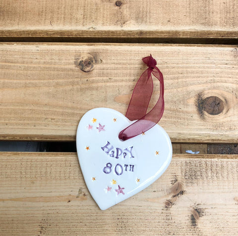 Hand painted ceramic heart featuring star design and the sentiment 'Happy 80th' Handmade in the UK using clay, glaze and paint sourced locally. Material: Ceramic