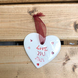 Hand painted ceramic heart featuring a flower design and the sentiment 'Love You Mum'  Handmade in the UK using clay, glaze and paint sourced locally.  Material:  Ceramic