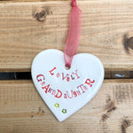 Hand painted ceramic heart featuring a flower design and the sentiment 'Lovely Granddaughter'  Handmade in the UK using clay, glaze and paint sourced locally.  Material:  Ceramic