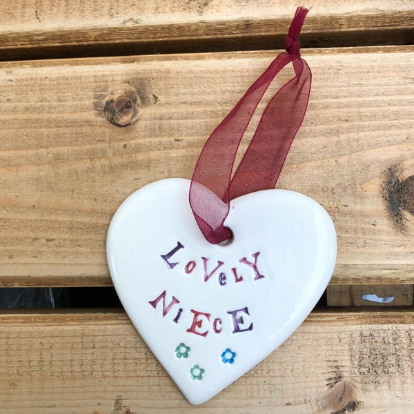 Hand painted ceramic heart featuring a flower design and the sentiment 'Lovely Niece'  Handmade in the UK using clay, glaze and paint sourced locally.  Material:  Ceramic