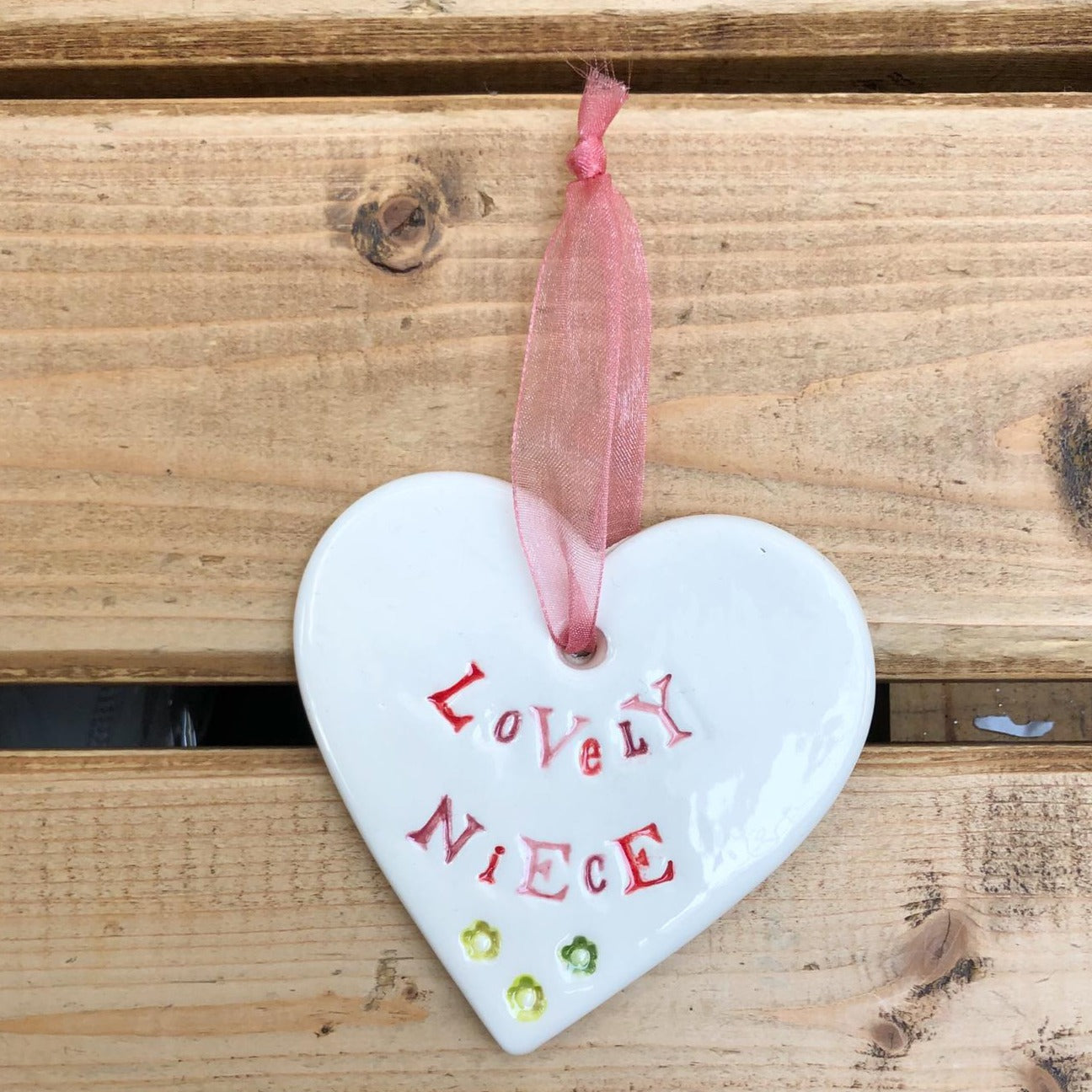Hand painted ceramic heart featuring a flower design and the sentiment 'Lovely Niece'  Handmade in the UK using clay, glaze and paint sourced locally.  Material:  Ceramic