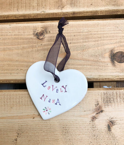Hand painted ceramic heart featuring a flower design and the sentiment 'Lovely Nana'  Handmade in the UK using clay, glaze and paint sourced locally.  Material:  Ceramic
