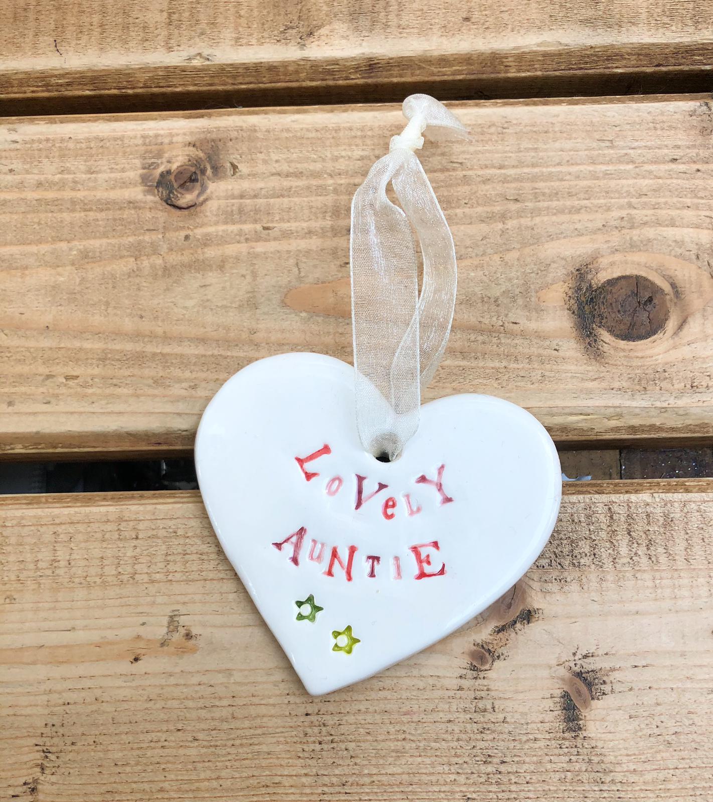 Hand painted ceramic heart featuring a flower design and the sentiment 'Lovely Auntie' Handmade in the UK using clay, glaze and paint sourced locally. Material: Ceram