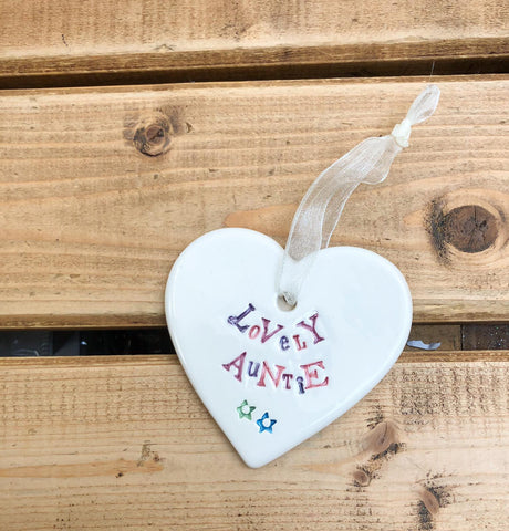 Hand painted ceramic heart featuring a flower design and the sentiment 'Lovely Auntie' Handmade in the UK using clay, glaze and paint sourced locally. Material: Ceram