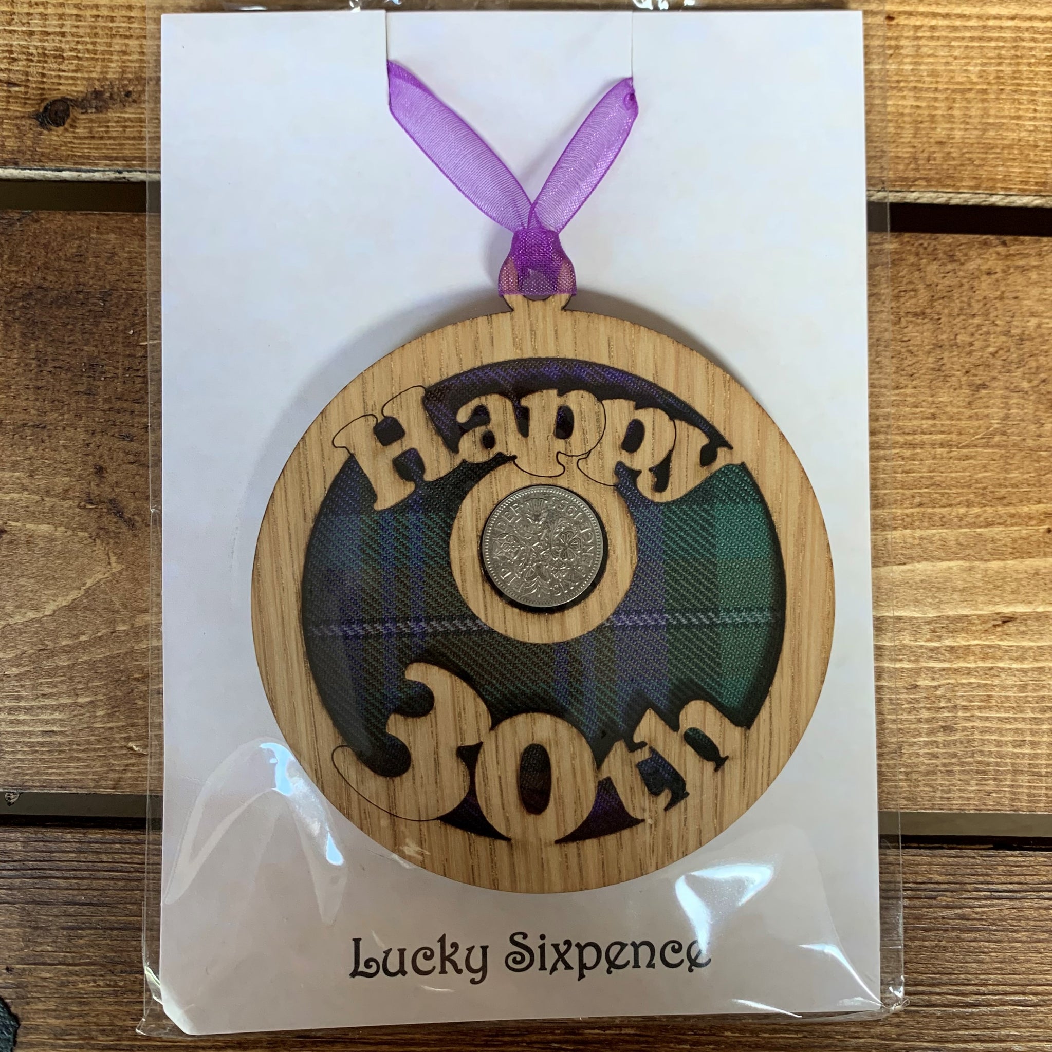 A unique keepsake gift with a Scottish twist.  The sixpence is mounted onto a round hanging oak veneered wood with tartan inserts, mounted on card and packaged in clear cellophane packets.  'Happy 30th' is cut into the wooden hanging.