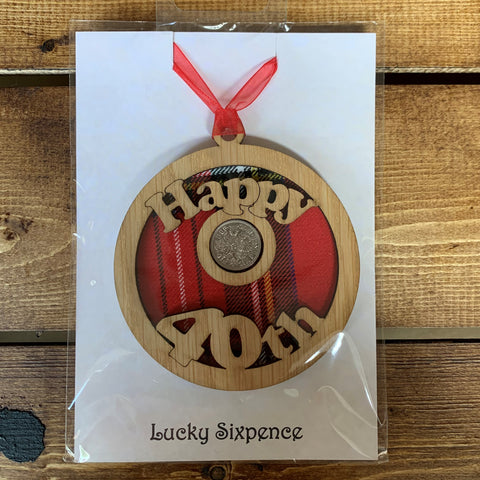 A unique keepsake gift with a Scottish twist.  The sixpence is mounted onto a round hanging oak veneered wood with tartan inserts, mounted on card and packaged in clear cellophane packets.  'Happy 40th' is cut into the wooden hanging.
