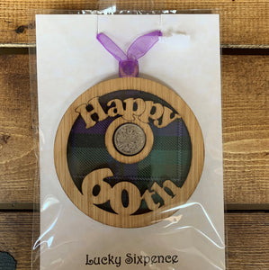 A unique keepsake gift with a Scottish twist.  The sixpence is mounted onto a round hanging oak veneered wood with tartan inserts, mounted on card and packaged in clear cellophane packets.  'Happy 60th' is cut into the round hanging.