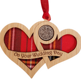 A unique keepsake gift with a Scottish twist.  The sixpence is mounted onto hanging oak veneered wooden interlocking hearts with tartan inserts, mounted on card and packaged in clear cellophane packets.  The sentiment 'On your Wedding Day' is engraved across the hearts.