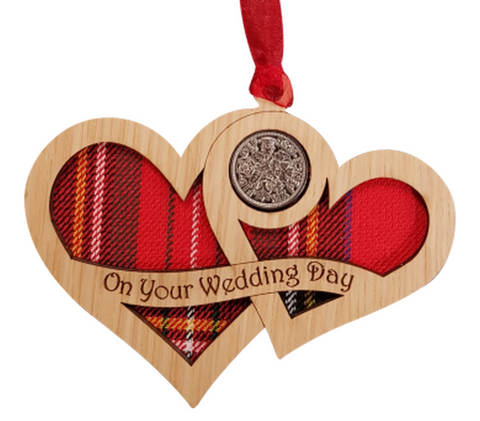 A unique keepsake gift with a Scottish twist.  The sixpence is mounted onto hanging oak veneered wooden interlocking hearts with tartan inserts, mounted on card and packaged in clear cellophane packets.  The sentiment 'On your Wedding Day' is engraved across the hearts.