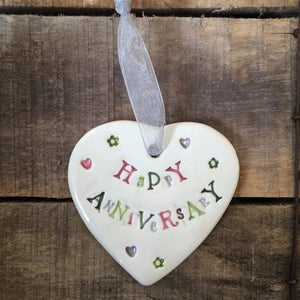 Hand painted ceramic heart featuring a heart and flower design and the sentiment 'Happy Anniversary' Handmade in the UK using clay, glaze and paint sourced locally. Material: Ceramic