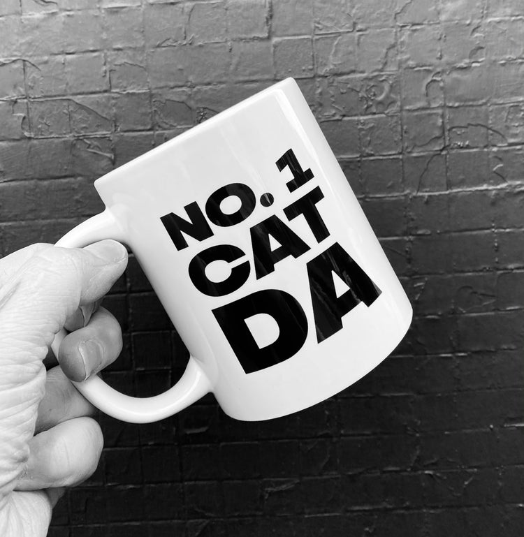 Mug with the slogan 'No.1 Cat Da' ......The perfect gift for that cat dad with a sense of humour .  Other variations available.  Printed in Glasgow.    Mug comes boxed.  Material:  11oz White Ceramic Mug