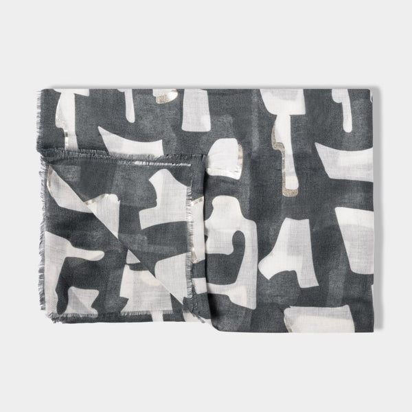 a folded scarf with a light navy coloured abstract block print and silver details